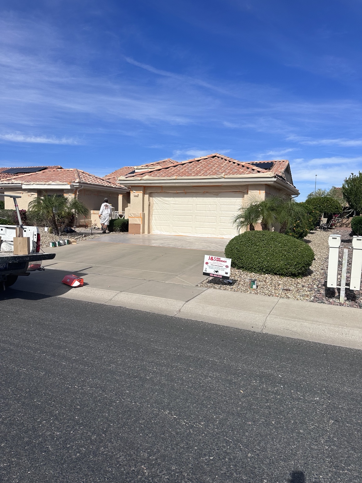 Garage, windows, and landscaping protected during exterior painting preparation